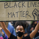 People hold up placards in support of the Black Lives Matter movement as they take part in the inaugural Million People March march from Notting Hill to Hyde Park in London on August 30, 2020, to put pressure on the UK Government into changing the “UK’s institutional and systemic racism.”